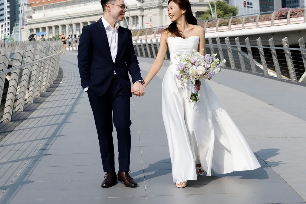 SERVICES 26 SINGAPORE BRIDAL GOWN BRIDE IN A STRAPLESS SATIN WEDDING GOWN RENTAL FROM K GOWN, WALKING WITH HER GROOM AT MARINA BAY, SINGAPORE